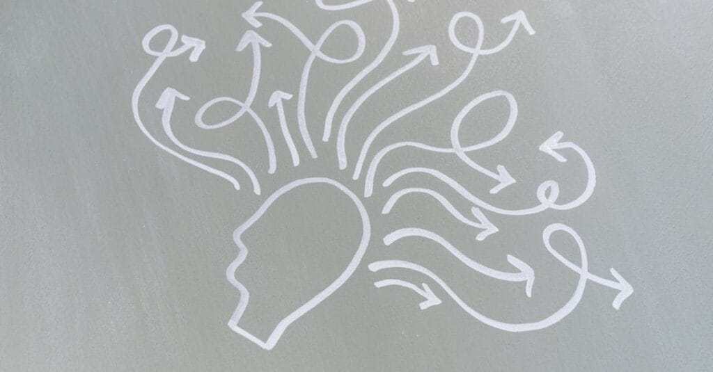 Chalk drawing of a head with swirling arrows represents mental activity and thought process.