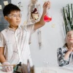 Two children experimenting with chemicals in a classroom, focusing on learning.