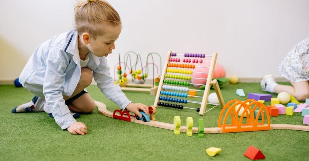 Young child playing with colorful educational toys indoors on a green carpet.
