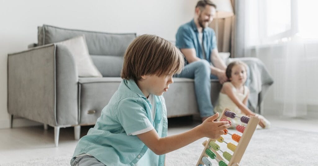 A boy playing with an abacus while family enjoys time together in a cozy living room.
