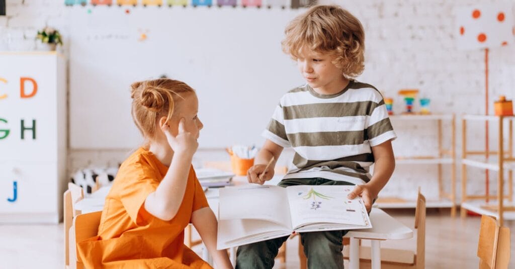 Two children engaged in reading and learning indoors at school.