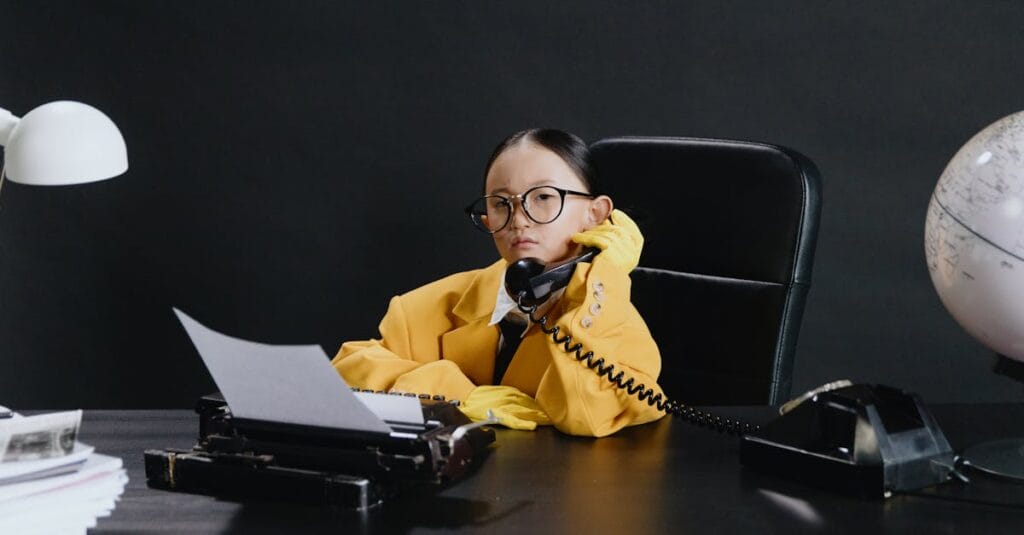 A child in a yellow suit sits at a desk with a phone, typewriter, and globe, portraying a business scene.