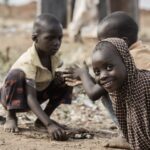 Smiling children in a rural area play together, creating joyful memories.