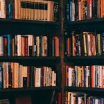 Corner view of a library with dark wooden bookshelves filled with a variety of books.
