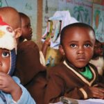 Children attentively seated in a vibrant classroom, immersed in educational activities.