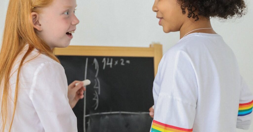 Two diverse girls discussing and solving a math equation on a chalkboard with enthusiasm.