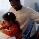 Father and daughter enjoying creative bonding time while writing a Christmas letter.