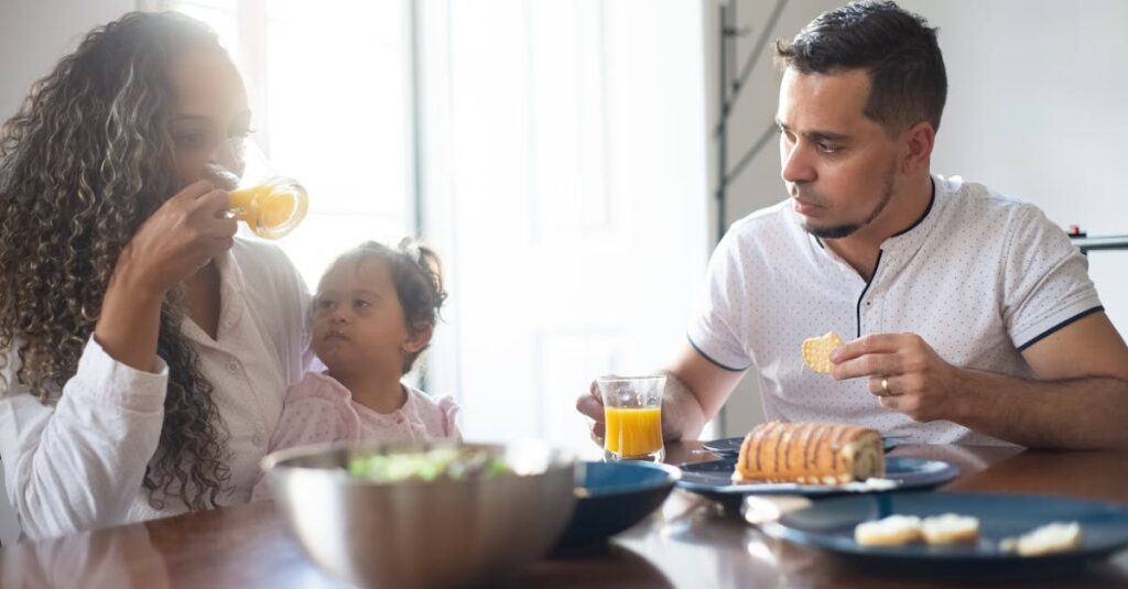 A family having breakfast at home, sharing food and drinks, embodying togetherness and love.