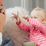 A mother and her daughter share a playful moment in a cozy living room setting.