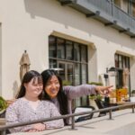 Mother and daughter share a special bonding moment on a sunny balcony.