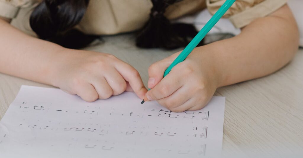 A young girl lying on the floor writing on a music sheet with a pencil indoors.
