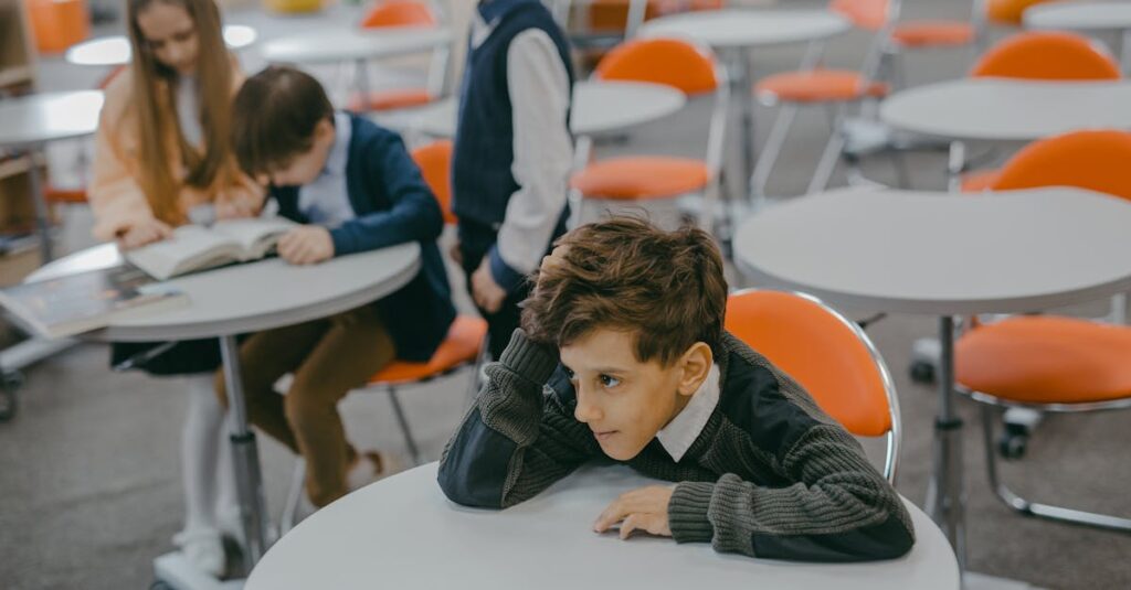 A young child feeling left out in a school classroom surrounded by peers.