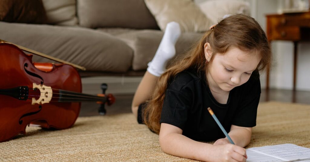 A child writing musical notes on sheet music while lying on a carpet indoors.