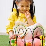 A young girl plays with educational toys, stimulating learning and creativity indoors.