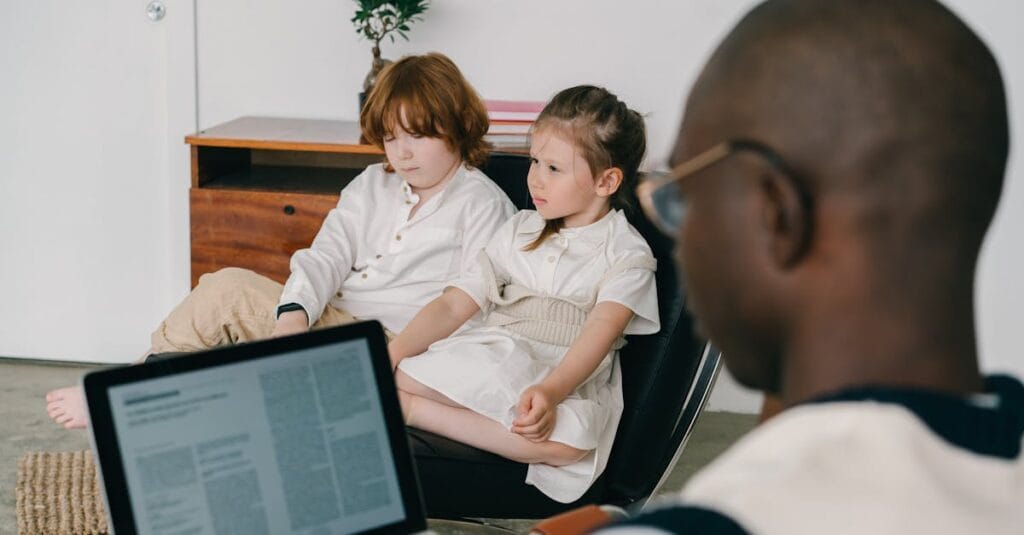 Therapist working with two children in an indoor therapy session, focusing on mental health.
