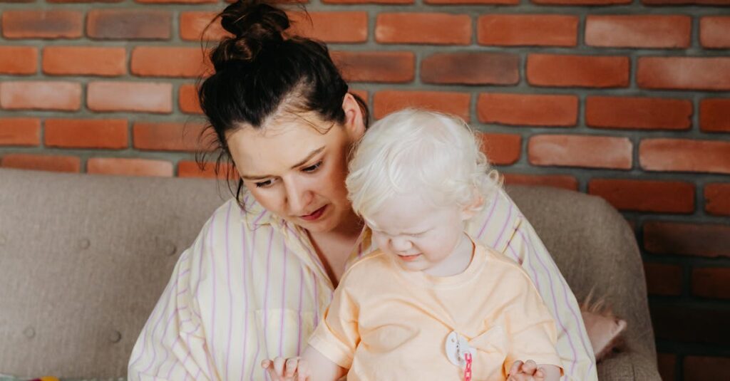 A mother and her albino child reading a book together on a sofa indoors.