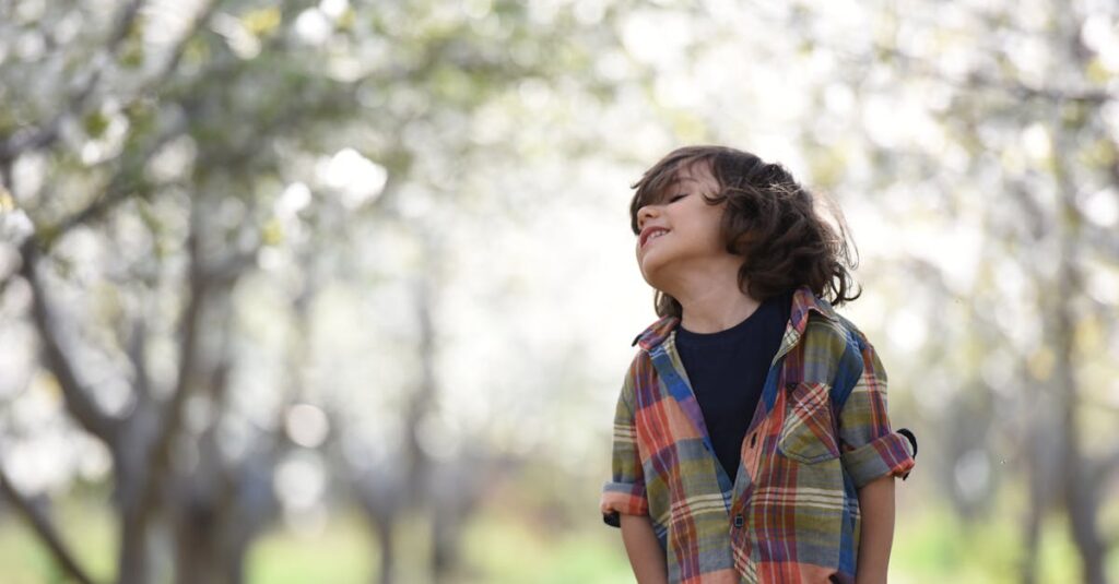 A joyful child in a colorful plaid shirt outdoors, enjoying a spring day.