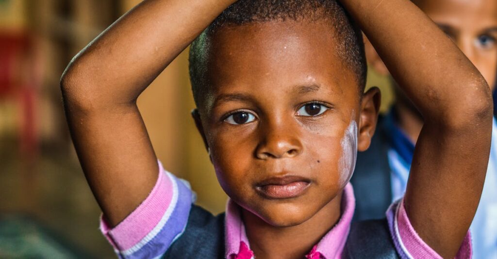 A young boy with contemplative expression indoors, emphasizing childhood and innocence.