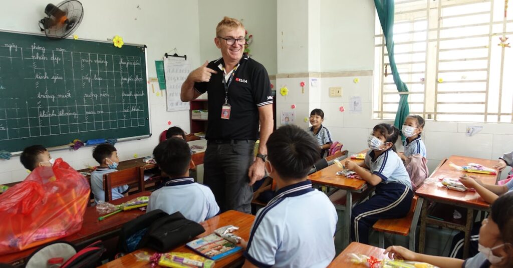 Teacher engaging with students in a vibrant Ho Chi Minh City classroom.