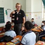 Teacher engaging with students in a vibrant Ho Chi Minh City classroom.