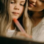 A loving mother and daughter bonding through art in a cozy setting.