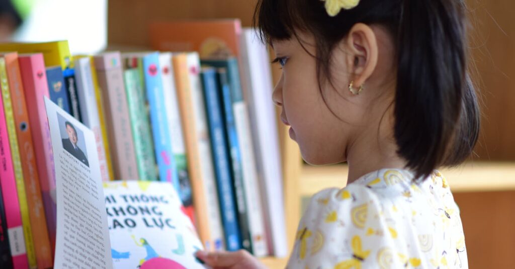 A young girl in a floral dress reading a book in front of a bookshelf.