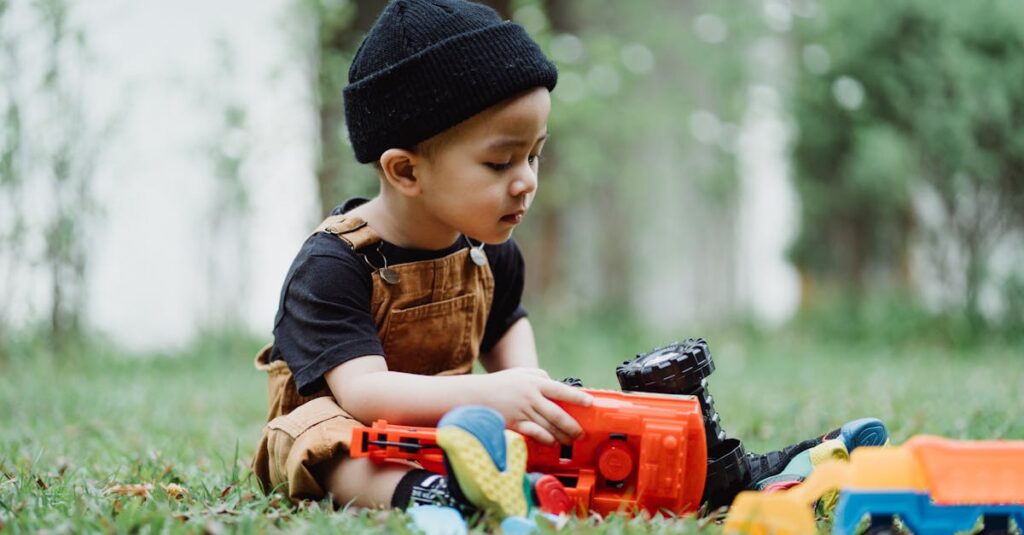A young boy in casual attire plays with colorful toys on a lawn, enjoying an outdoor moment.
