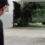 A young boy joyfully runs towards his father outdoors, capturing a playful family moment.