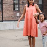 Two girls smiling while playing outdoors. Capturing joyful moments of sibling bonding.