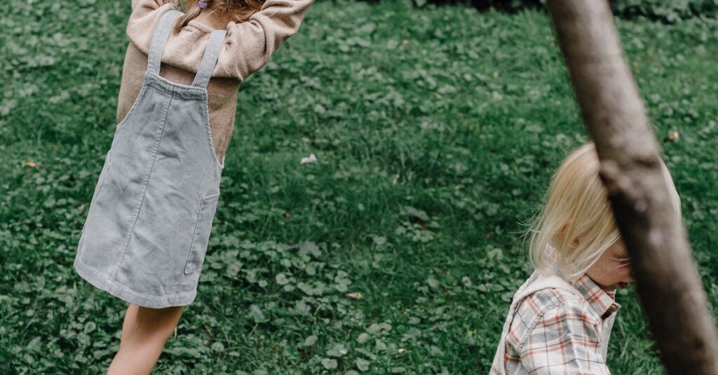 Two kids enjoying playful activities in a lush green yard during the day.