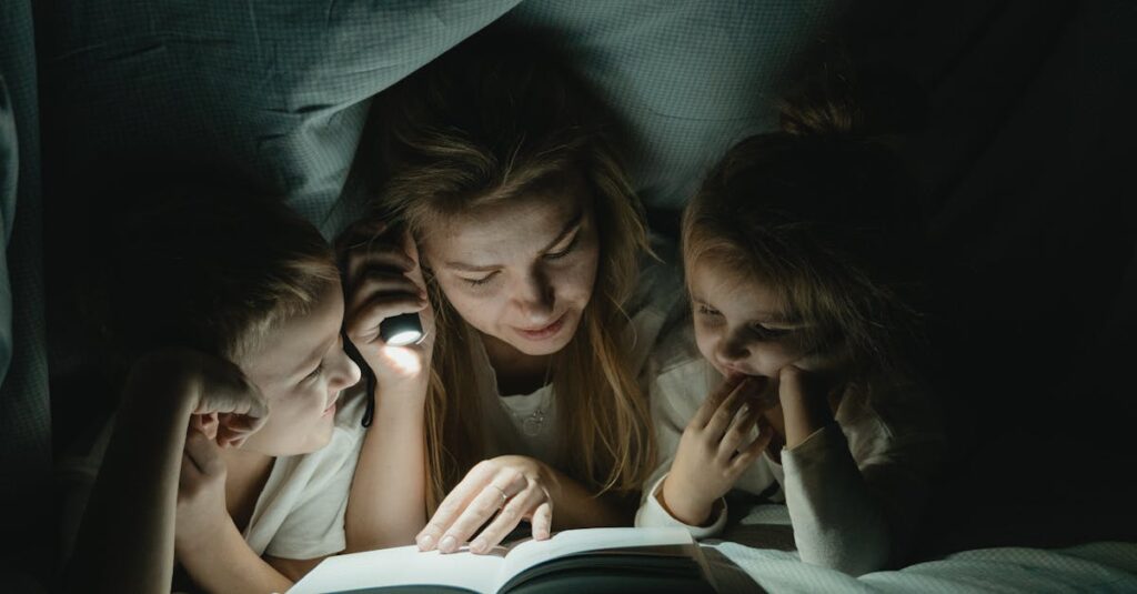 Mother reading a book to her children under a cozy blanket tent, bonding time.