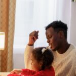 A dad and child bond over creative drawing at home during the festive Christmas season.