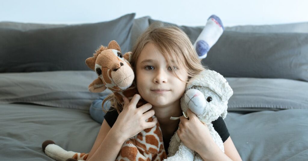 A young girl enjoys her time indoors, cuddled with stuffed toys on a cozy bed.