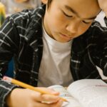 Students studying attentively at their desks in a classroom environment.