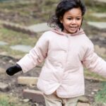 A cheerful child enjoying an Easter egg hunt in a backyard, expressing joy and excitement.
