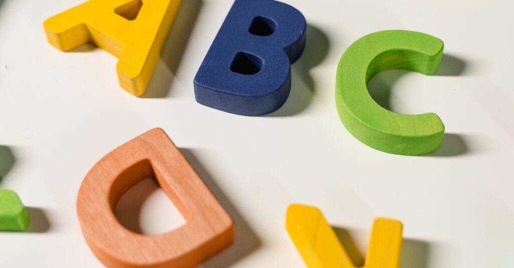 Bright and colorful wooden alphabet letters scattered on a white surface.