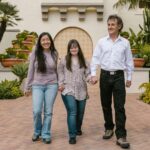A family enjoys a walk in a beautiful garden, highlighting love and Down syndrome awareness.