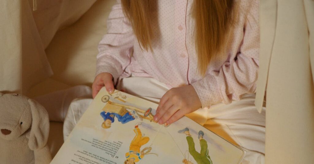 A young girl reads a storybook inside a cozy, illuminated tent indoors. Perfect bedtime moment.
