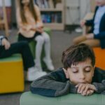 Child feeling isolated in a classroom while peers interact. Emphasizes themes of loneliness and social dynamics.