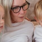 A grandmother and her grandchildren enjoy quality time together indoors.