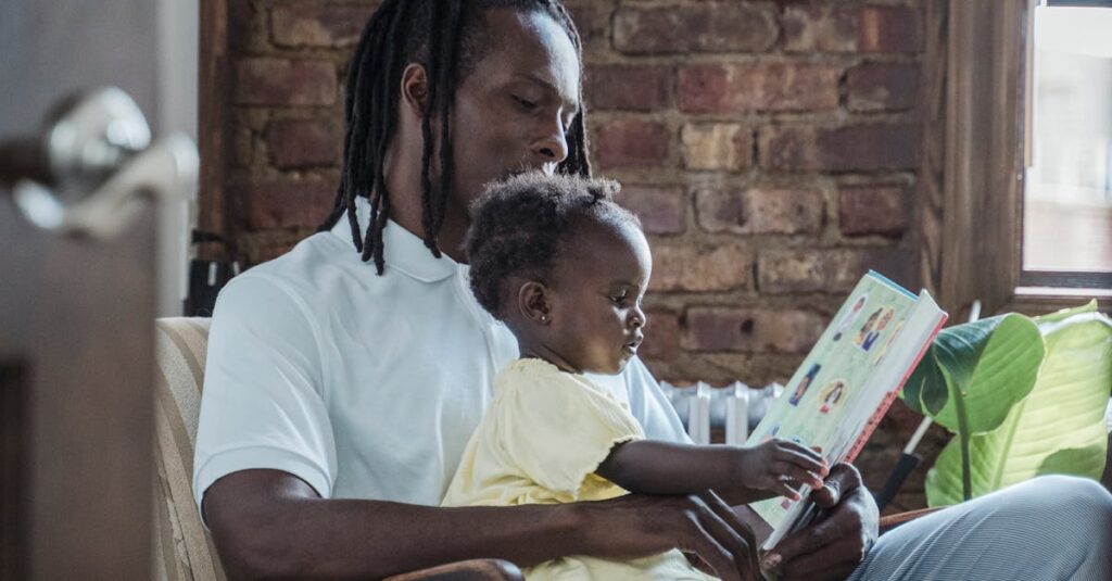 A father and child bonding while reading a book together at home, creating a warm family moment.