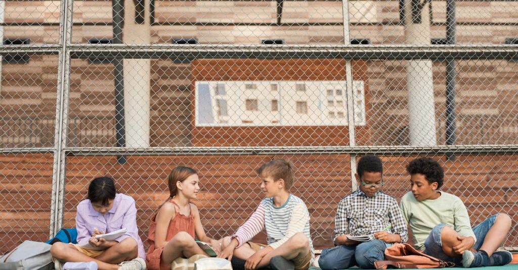 A group of teenagers studying collaboratively on an outdoor sports ground.