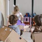 Joyful kids playing indoors with creative cardboard costumes.
