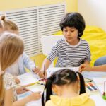 Children engaging in a creative arts and crafts session in a bright preschool classroom.