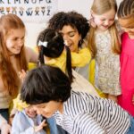 Happy preschoolers and teacher bonding in a colorful classroom setting, fostering friendship and education.