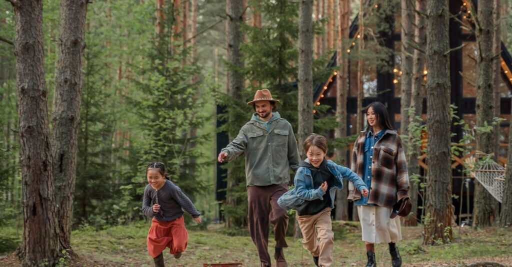 Happy family playing and running through the forest, enjoying a vacation together.