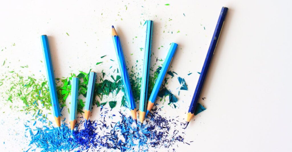Creative display of colored pencils and vibrant shavings on a white background.