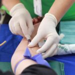 A healthcare professional administering an injection to a patient's arm during a medical procedure.