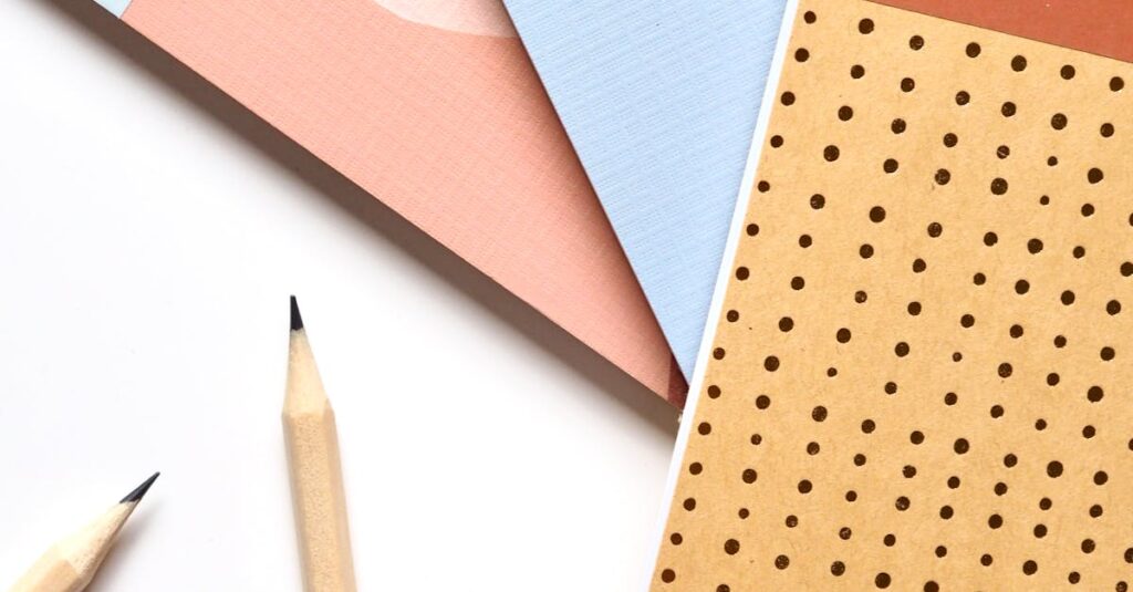 Colorful notebooks and pencils arranged neatly for a creative workspace.