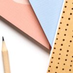 Colorful notebooks and pencils arranged neatly for a creative workspace.